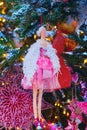 Christmas tree branch with woman doll, close-up. New Year retro ornament for festive