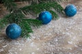 Christmas tree branches, blue balls on winter snowbound wooden b