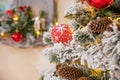 Christmas tree branches on blurred background with red balls and golden decor, berries, garland, cone. Christmas snowy Royalty Free Stock Photo