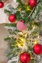 Christmas tree branches on blurred background with red balls and golden decor, berries, garland, cone. Christmas snowy Royalty Free Stock Photo