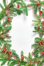 Christmas tree branches in the form of a frame, decorated with a red garland with bells and stars. flat lay, space for a text Royalty Free Stock Photo