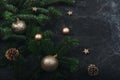 Christmas tree branches, golden baubles and pine cones on black background. New Year concept. Top view, copy space Royalty Free Stock Photo