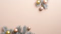 Christmas tree branches with golden, silver and pink Xmas balls on beige background with copy space. New Year greeting card Royalty Free Stock Photo