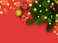 Christmas tree branches with ornaments and defocused lights on red background Royalty Free Stock Photo