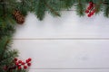 Christmas tree branches with pinecone and red berries on white wooden background and copy space for your text. Flat lay Royalty Free Stock Photo