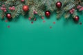 Christmas tree branches, red glass balls on green with copy space. Top view. Holiday card Royalty Free Stock Photo