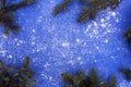 Christmas tree branches and snow lie on a blue background with space for text. Royalty Free Stock Photo