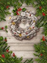 Christmas tree branches, wreath decoration and red berries on grey wooden background Royalty Free Stock Photo