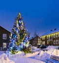 Christmas tree with bright lights on the street near the houses decorated for Christmas and New Year Eve Royalty Free Stock Photo