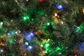 Christmas tree with bright string lights, closeup. Bokeh effect