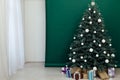 Christmas tree pine Christmas decoration interior of the green room with holiday postcard gifts