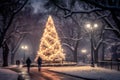 Christmas tree in city park, decorated with garland lights. Winter evening in snowy weather. Blurred silhouettes of people Royalty Free Stock Photo