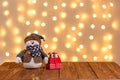 Christmas tree, clock, sledge, snowman, candles, gifts on a wooden background and lights background