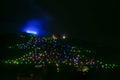 Christmas tree composed of colored lights and white comet star, extends through the woods above the hill Royalty Free Stock Photo