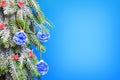 A Christmas tree covered with frost is decorated with paper balls and flags on a blue background. Christmas background Royalty Free Stock Photo