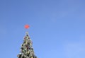 Christmas tree decorated with Christmas balls and red star outdoors with copy space on blue sky background Royalty Free Stock Photo