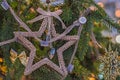 Christmas tree is decorated with beads and a star. Multi-colored garlands on a blurry background. Happy New Year