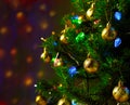 Christmas tree decorated with blue and green lights on a semi-blurred background of lights Royalty Free Stock Photo