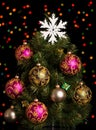 Christmas tree decorated with colorful balls, gifts and snowflake, on dark background Royalty Free Stock Photo