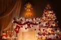 Christmas tree decorated with Lights in Fireplace Room with Candles, Red Stocking, Wreath and Clock on Wall. Shining White Xmas Royalty Free Stock Photo