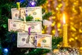 Christmas tree decorated with one hundred dollar bills with candle light_ Royalty Free Stock Photo