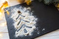 Christmas tree decorated with snow from flour on the black on shale food board background. Merry Christmas and Happy New Year conc