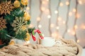 A Christmas tree decorated snowflakes and a garland, cup of coffee, candy with knitted scarf on the background Royalty Free Stock Photo