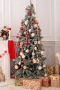 Christmas  tree decorated with toys, balls and lights glowing garlands in living room. Beautiful decorated Christmas tree with gif Royalty Free Stock Photo