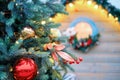 Christmas tree decorated with toys near a wooden house with a round window. Preparing for the new year and Christmas celebrations Royalty Free Stock Photo