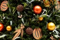 Christmas tree decorated in tropical style with golden and orange ornaments ball. Close up Royalty Free Stock Photo