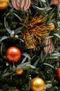 Christmas tree decorated in tropical style with golden and orange ornaments ball. Close up Royalty Free Stock Photo