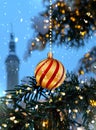 Christmas tree decoration  festive balls red and yellow gold decoration  on green snowy   branch  snowy Tallinn old town hall sq Royalty Free Stock Photo