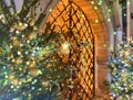Christmas tree decoration illuminated gold blue light  on medieval street near metal decorative gate  door  in Tallinn Old town ho Royalty Free Stock Photo