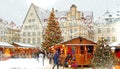 Christmas tree decoration on market place people walking snow man on medieval town hall square at Tallinn Old Town winter holiday