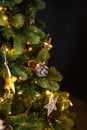 Christmas tree decorations in a dark key, garland and golden wood toys, pine cones and lights. Royalty Free Stock Photo