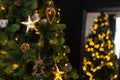 Christmas tree decorations in a dark key, garland and golden wood toys. Royalty Free Stock Photo