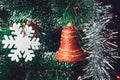 Christmas Tree Decorations: Red Orange Bell, White Snowflake, Shining Silver Tinsel on Green Needles with White Tips. Happy New Royalty Free Stock Photo