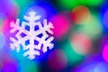 Christmas-tree decorations - snowflake against blurred garland lights background. Royalty Free Stock Photo