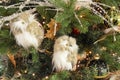 Christmas tree decorations. White glass owl, golden Christmas bauble, white feathers and lights in a pine tree. Close up Royalty Free Stock Photo