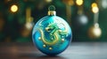 Christmas tree decorative blue ball with the image of terrible green eastern dragon, on a background of yellow shiny bokeh