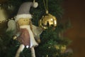 Christmas tree with decorative doll with wings like an angel and a golden ball hanging Royalty Free Stock Photo