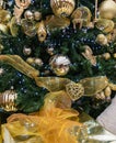 Christmas tree detail with golden christmas bauble. Christmas tree lights and decorations