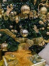 Christmas tree detail with golden christmas bauble. Christmas tree lights and decorations