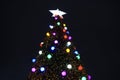 A christmas tree with different colored bright lights