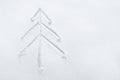 Christmas tree drawn in the snow with a stick. Tree for New Year drawn schematically. Greeting card for new year. Winter