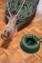 Christmas tree fastener. hands place a tree holder near a packaged Christmas tree on the floor. View from above. Floor Royalty Free Stock Photo