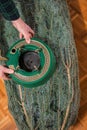 Christmas tree fastener. hands place a tree holder near a packaged Christmas tree on the floor. View from above. Floor Royalty Free Stock Photo