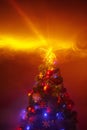 Christmas tree with festive lights, orange background with smoke Royalty Free Stock Photo