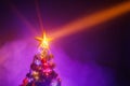 Christmas tree with festive lights, purple background with smoke Royalty Free Stock Photo