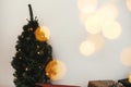 Christmas tree with festive stylish gifts in golden lights bokeh in white room. Happy Holidays. Merry Christmas.Winter holidays Royalty Free Stock Photo